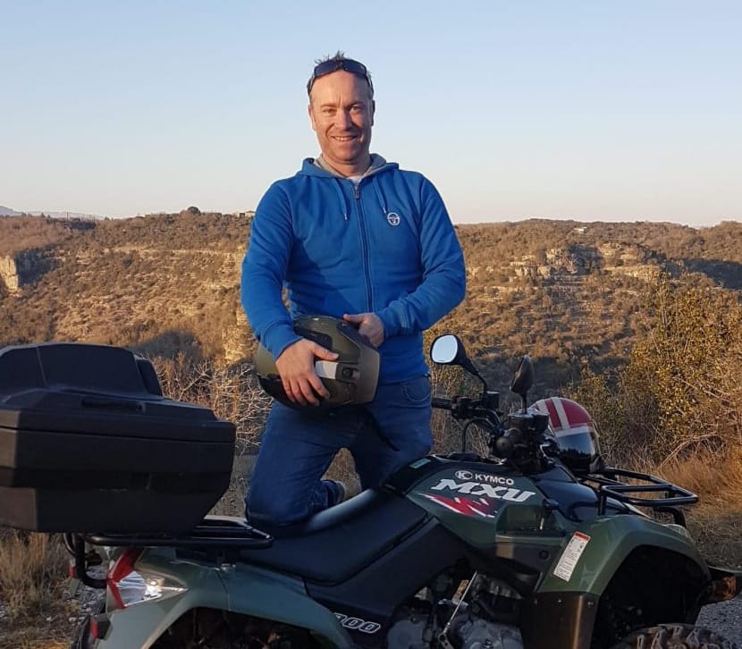 portrait d'eddy frometin sur un quad avec en arrière plan les montagnes ardéchoises